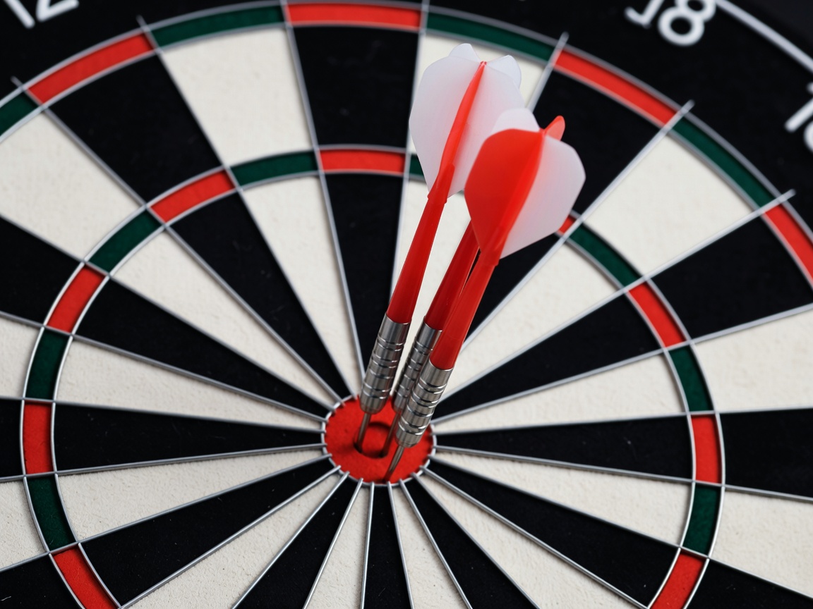 Darts grouped tightly in the treble twenty bed